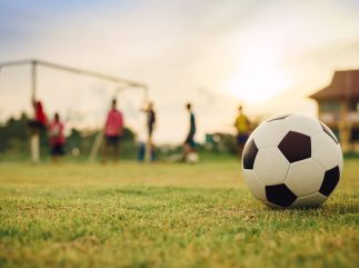 Action sport outdoors of kids having fun playing soccer football