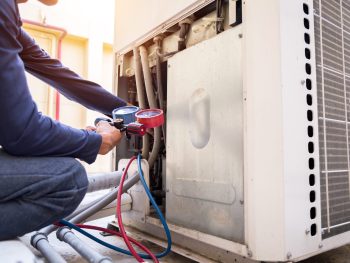 A technician checking an AC unit